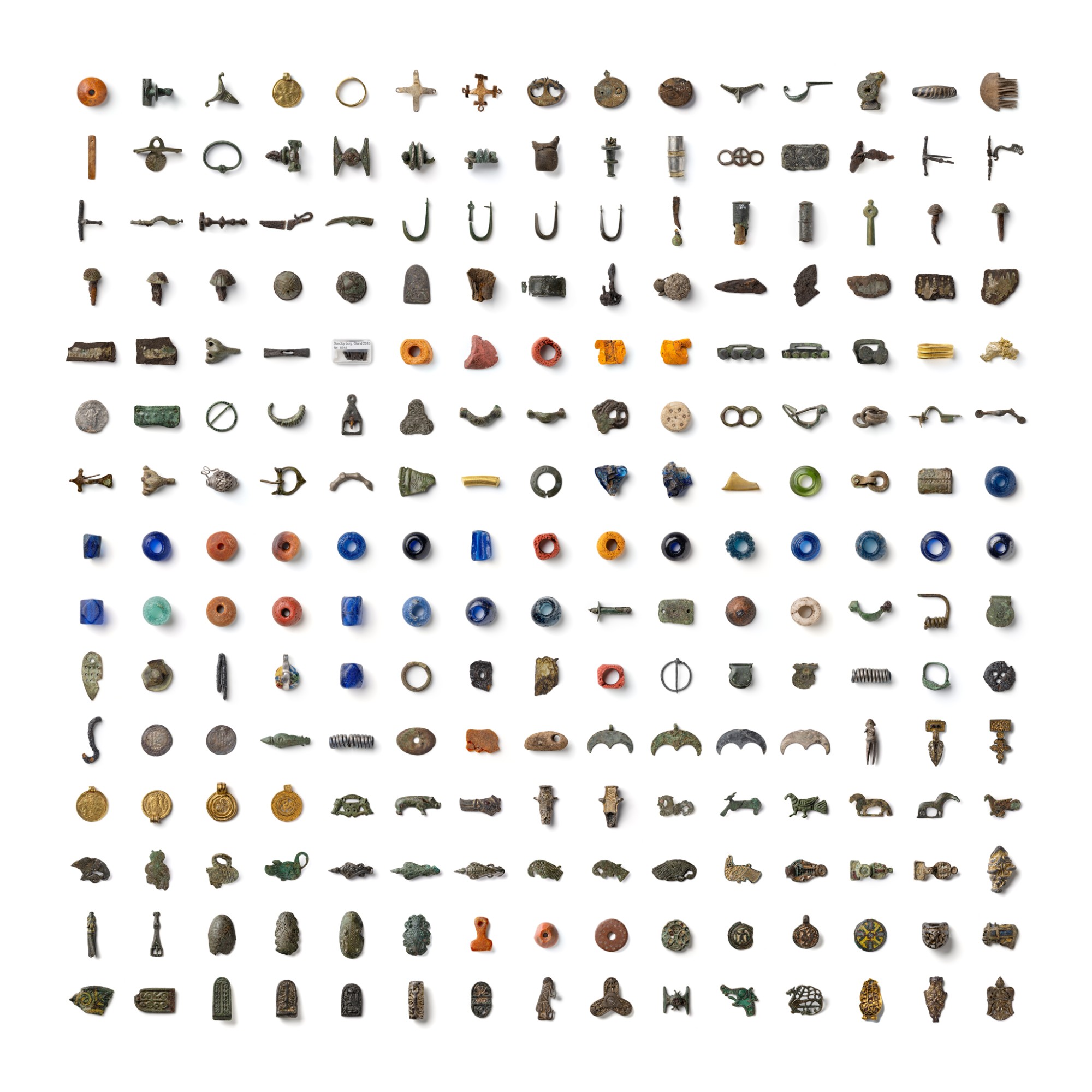 A square grid of 225 archaeological objects on white — beads, brooches, mounts, pendants, coins and fragments — each photographed with the same light from the upper left